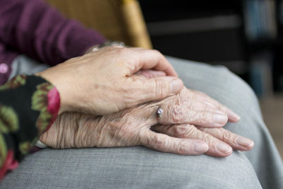 Pflegerin nimmt Älteren Menschen an der Hand